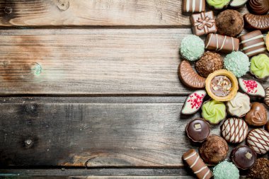 Çikolatalı tatlılar ile fındık ve çeşitli dolgular. Ahşap bir arka plan üzerinde.