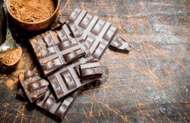 Kakao tozu ile çikolata. Ahşap bir arka plan üzerinde.