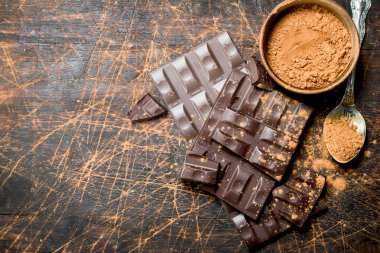 Kakao tozu ile çikolata. Ahşap bir arka plan üzerinde.