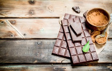 Çikolata kakao tozu ile. Ahşap bir arka plan üzerinde.