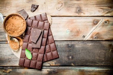 Çikolata kakao tozu ile. Ahşap bir arka plan üzerinde.