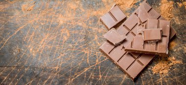 Kakao tozu ile Çikolatalı dilimler. Ahşap bir arka plan üzerinde.