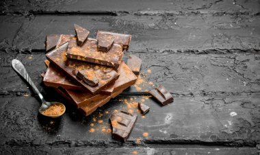 Çikolata kakao tozu ile farklı türde ürün yelpazesine. Rustik siyah arka plan üzerine.