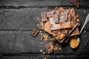 Çikolata kakao tozu ile farklı türde ürün yelpazesine. Rustik siyah arka plan üzerine.