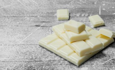 Beyaz çikolata parçaları. Rustik bir arka plan üzerinde.