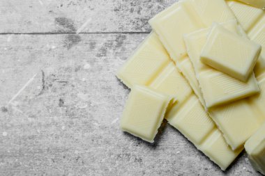 Beyaz çikolata parçaları. Rustik bir arka plan üzerinde.