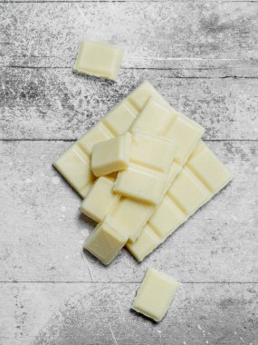 Beyaz çikolata parçaları. Rustik bir arka plan üzerinde.