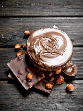 Fındık ile çikolata ezmesi. Ahşap bir arka plan üzerinde.