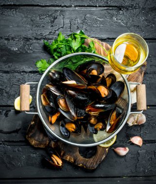 Taze deniz ürünleri deniz tarağı beyaz şarap ve maydanoz ile. Rustik siyah arka plan üzerine.