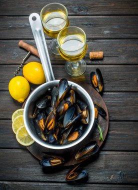 Taze deniz ürünleri bardak beyaz şarap ile deniz tarağı. Ahşap bir arka plan üzerinde.