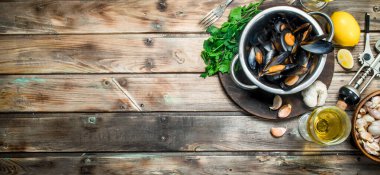 Beyaz şarap bir tencerede taze deniz ürünleri istiridye. Ahşap bir arka plan üzerinde.