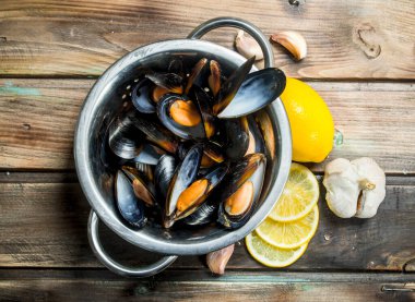 Limon dilimleri ile taze deniz ürünleri istiridye. Ahşap bir arka plan üzerinde.