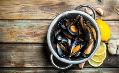 Limon dilimleri ile taze deniz ürünleri istiridye. Ahşap bir arka plan üzerinde.