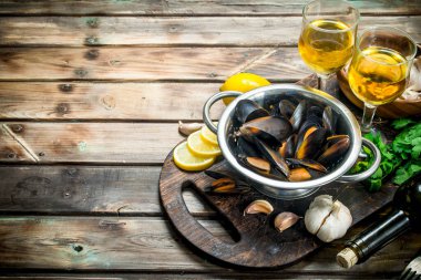 Beyaz şarap bir tencerede taze deniz ürünleri istiridye. Ahşap bir arka plan üzerinde.