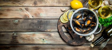 Beyaz şarap bir tencerede taze deniz ürünleri istiridye. Ahşap bir arka plan üzerinde.