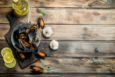 Limon dilimleri ile taze deniz ürünleri istiridye. Ahşap bir arka plan üzerinde.