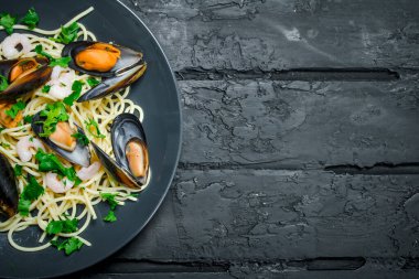 Akdeniz yemekleri. Deniz ürünleri istiridye spagetti. Siyah bir rustik arka planda.