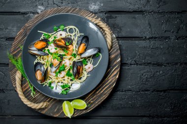 Akdeniz yemekleri. Deniz ürünleri istiridye spagetti. Siyah bir rustik arka planda.