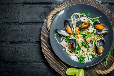 Akdeniz yemekleri. Deniz ürünleri istiridye spagetti. Siyah bir rustik arka planda.