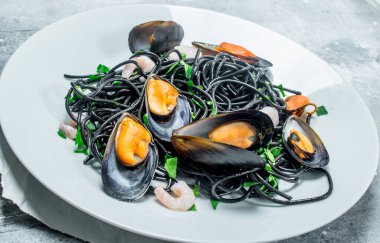 Akdeniz makarna. Mürekkep balığı mürekkep ve istiridye spagetti. Rustik bir arka plan üzerinde.