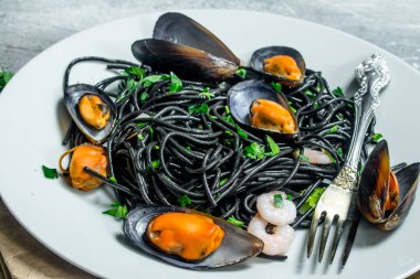 Akdeniz makarna. Mürekkep balığı mürekkep ve istiridye spagetti. Rustik bir arka plan üzerinde.