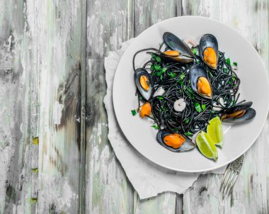 Akdeniz makarna. Mürekkep balığı mürekkep ve istiridye spagetti. Rustik bir arka plan üzerinde.