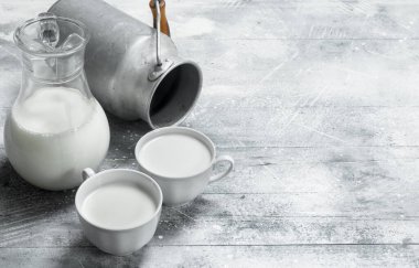 Kupalar ile bir kutu süt. Rustik bir arka plan üzerinde .