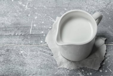 Kağıt üzerinde bir bardak süt. Rustik bir arka plan üzerinde .