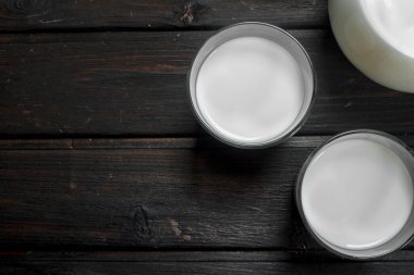 Taze süt içinde gözlük. Ahşap bir arka plan üzerinde.