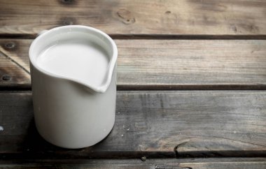 Bir bardak taze süt. Ahşap bir arka plan üzerinde.