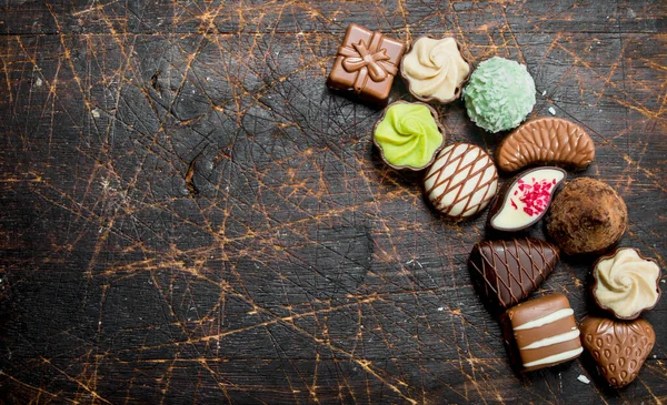 Schokoladenbonbons Mit Nüssen Und Verschiedenen Füllungen Auf Einem Hölzernen Hintergrund — Stockfoto