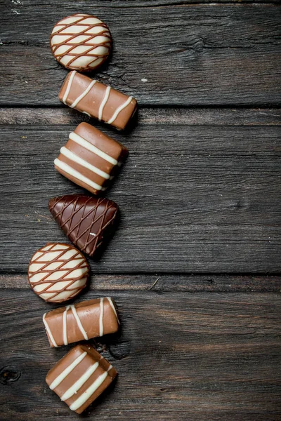 Schokoladenbonbons Mit Nüssen Und Verschiedenen Füllungen Auf Einem Hölzernen Hintergrund — Stockfoto