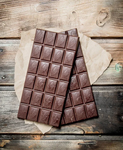 Schokoladentafeln Auf Papier Auf Einem Hölzernen Hintergrund — Stockfoto