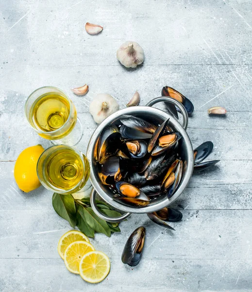 Şarap ve limon dilimleri ile taze deniz ürünleri istiridye. Rustik bir arka plan üzerinde.