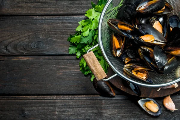 Taze deniz ürünleri istiridye yeşil maydanoz ile. Ahşap bir arka plan üzerinde.