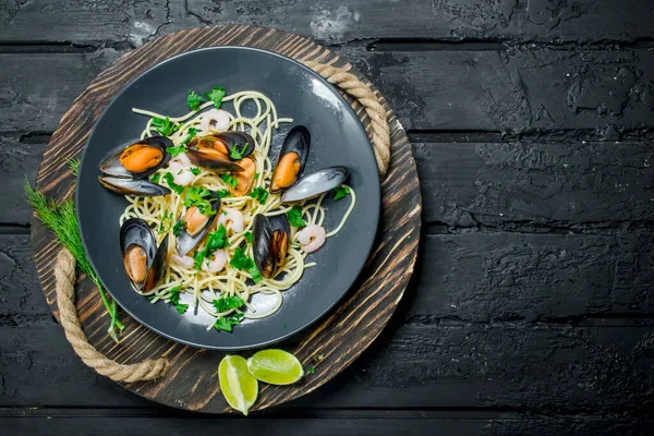 Akdeniz yemekleri. Deniz ürünleri istiridye spagetti. Siyah bir rustik arka planda.
