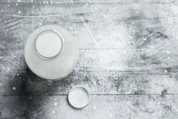 stock image The milk in the bottle. On a rustic background .