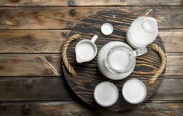 stock image Fresh milk in glasses on board. On a wooden background.