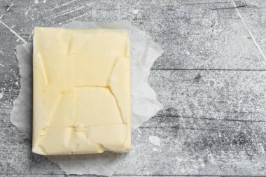 Kağıt üzerine tereyağı. Rustik bir arka plan üzerinde.