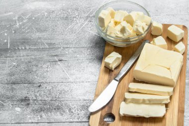 Bir ahşap tahta üzerine tereyağı. Rustik bir arka plan üzerinde.