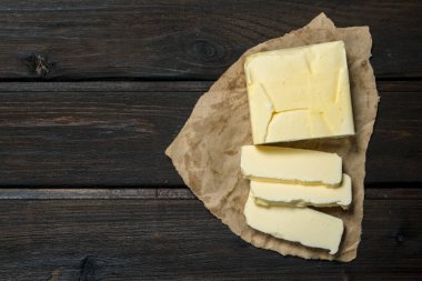 Kağıt üzerine tereyağı. Ahşap bir arka plan üzerinde.