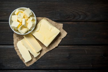 Kağıt üzerine tereyağı. Ahşap bir arka plan üzerinde.