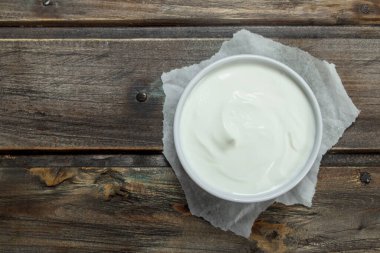 Kase taze ekşi krema. Ahşap bir arka plan üzerinde.