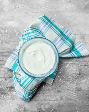 Ekşi krema kase. Rustik bir arka plan üzerinde.