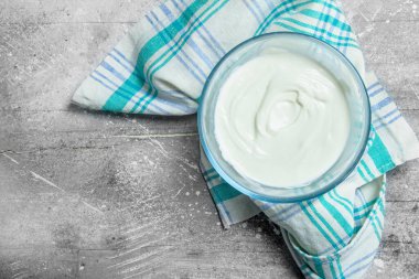 Ekşi krema kase. Rustik bir arka plan üzerinde.