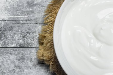 Ekşi krema kase. Rustik bir arka plan üzerinde.