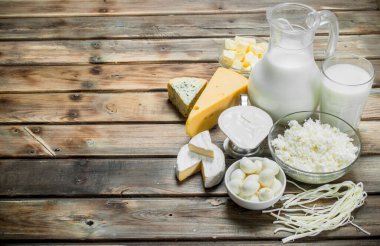 Taze süt ve süt ürünleri çeşitli. Ahşap bir arka plan üzerinde.