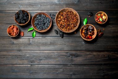 Kurutulmuş meyve kase çeşitleri ürün yelpazesine. Ahşap bir arka plan üzerinde.
