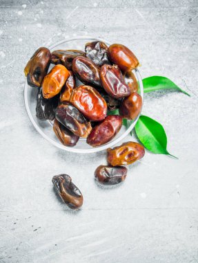 Tarihleri kase. Rustik bir arka plan üzerinde.