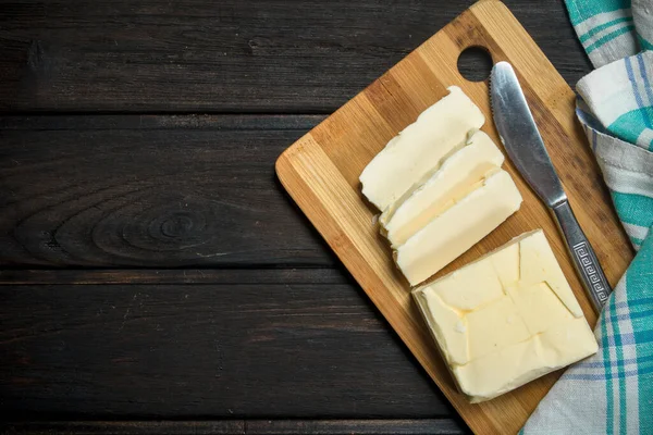 stock image Butter on a wooden Board. On a wooden background.